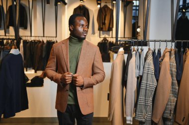 Premium erkek giyim mağazasında şık takım elbiseli Afrikalı bir işadamı.