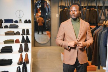 Yakışıklı bir Afrikalı beyefendi zarif bir takım elbise alıyor..