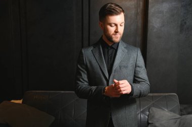 Arkaplanda zarif bir takım elbise içindeki yakışıklı bir adamın portresi..