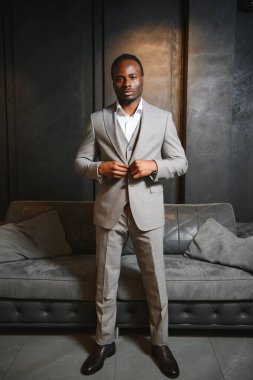 Koyu gri arka planda klasik takım elbiseli Afrikalı bir adam. Klasik giyim konsepti.