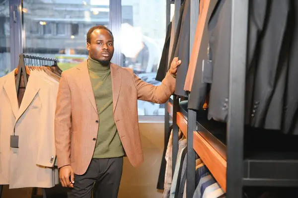 Klasik davalı Afrikalı İşadamı dükkandaki takım elbiseli adamlara karşı.