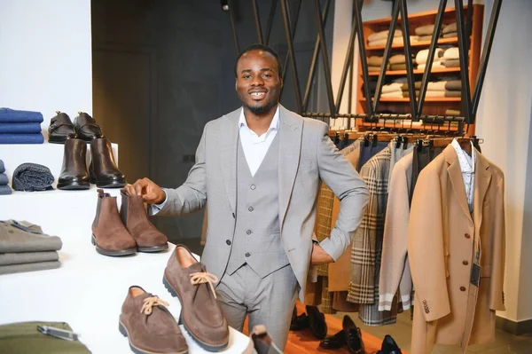 Genç yakışıklı bir adam dükkanda ayakkabı seçiyor..