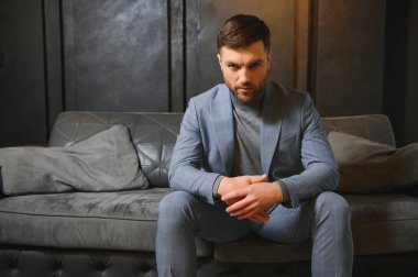 Arkaplanda zarif bir takım elbise içindeki yakışıklı bir adamın portresi..