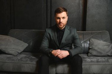 Arkaplanda zarif bir takım elbise içindeki yakışıklı bir adamın portresi..