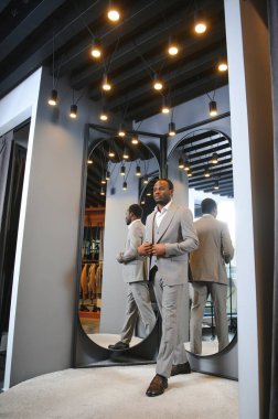 Yakışıklı bir Afrikalı beyefendi zarif bir takım elbise alıyor..