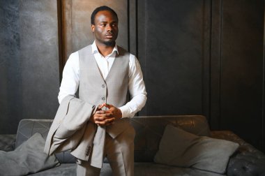 Premium erkek giyim mağazasında şık takım elbiseli Afrikalı bir işadamı.