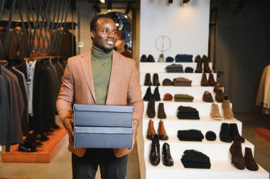 Premium erkek giyim mağazasında şık takım elbiseli Afrikalı bir işadamı.