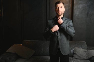 Arkaplanda zarif bir takım elbise içindeki yakışıklı bir adamın portresi..