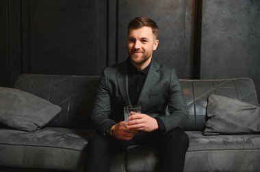 Arkaplanda zarif bir takım elbise içindeki yakışıklı bir adamın portresi..