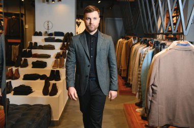 Gülümseyen, seyir ve klasik seçme Modern genç yakışıklı işadamı uygun takım elbise dükkanı.