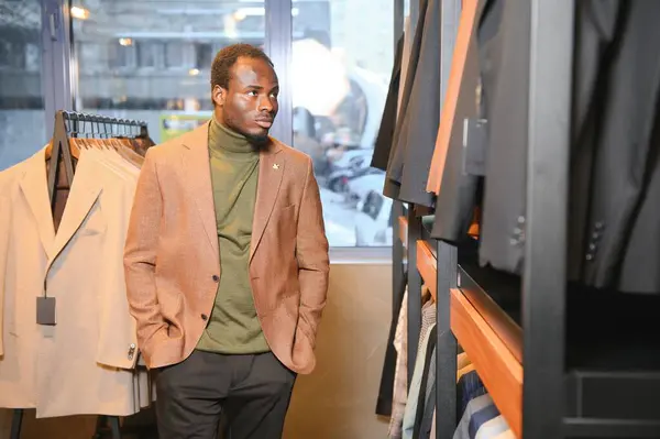 Genç Afrikalı adam giyim mağazasından alışveriş yapıyor..