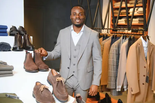 Klasik davalı Afrikalı İşadamı dükkandaki takım elbiseli adamlara karşı.