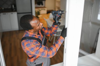 Afrikalı servis elemanı pencere kuruyor.