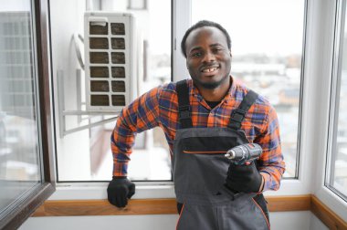 Profesyonel bir elektrikçi ağır klimayı tamir ediyor..