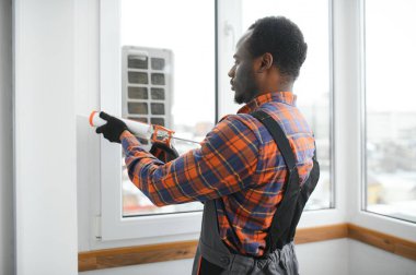 Afrikalı servis elemanı pencere kuruyor.