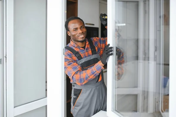 African service man installing window.