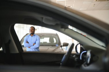 Genç Afro-Amerikan adam galeride ya da araba galerisinde otomobilleri görmeye geldi..