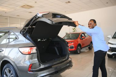 Yakışıklı Afrikalı adam galeride yeni bir araba seçiyor..