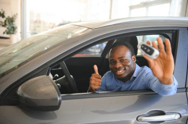 Neşeli siyah adam lüks otomobilde oturuyor, test sürüşü, ulaşım.