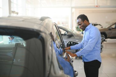 Yakışıklı Afrikalı adam galeride yeni bir araba seçiyor..