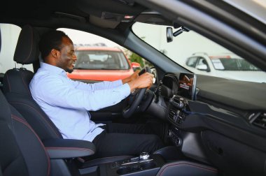 Yakışıklı Afrikalı adam galeride yeni bir araba seçiyor..