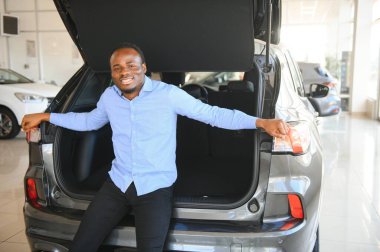 Yakışıklı Afrikalı adam galeride yeni bir araba seçiyor..