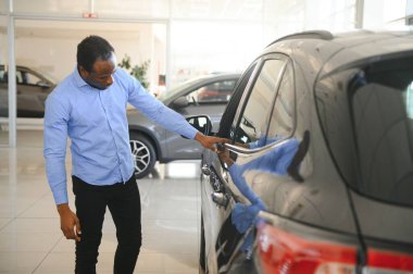 Yakışıklı Afrikalı adam galeride yeni bir araba seçiyor..