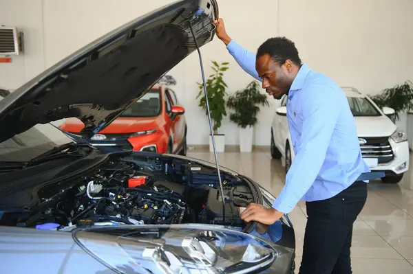 Yakışıklı Afrikalı adam galeride yeni bir araba seçiyor..