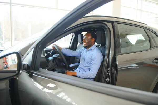 Happy Car Buyer, New Car Owner Concept. Portrait Of Excited Young African American Guy In Dealership Showroom.