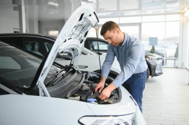 Galeride ilk elektrikli araba alan genç adam. Eko araba satışı kavramı.