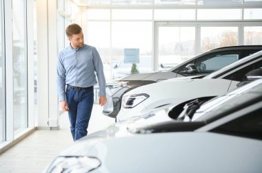 Galeride ilk elektrikli araba alan genç adam. Eko araba satışı kavramı.