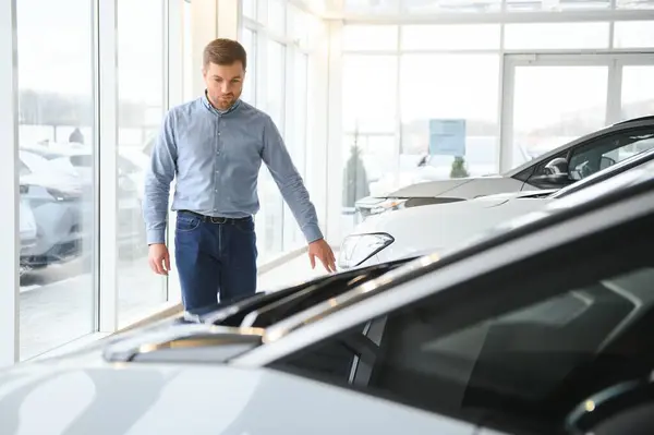 Man adult customer male buyer client chooses auto wants to buy new automobile.