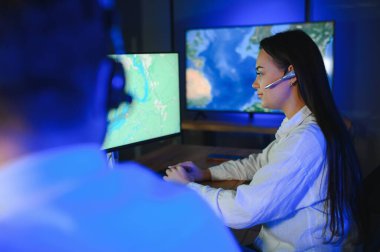 Gülümseyen arkadaş canlısı çağrı merkezi ajanı, kulaklıkla ofiste yardım hattında çalışıyor..