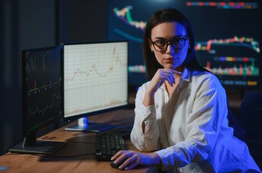 Kadın tüccar. Bayan bilgisayarla yatırım yapıyor. İş kadını hisse senedi fiyatlarını takip ediyor.