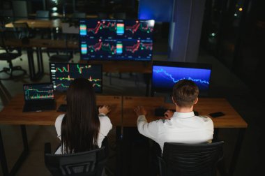 İşletme takımı yatırımı bilgisayarla çalışıyor, borsa işlemlerini planlıyor ve analiz ediyor..