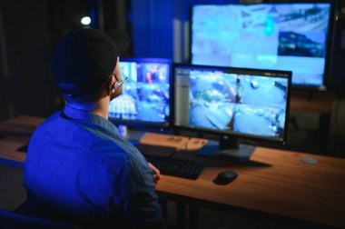 Güvenlik operatörü gece ofisindeki güvenlik kameralarını kontrol ediyor. Modern güvenlik sistemi ve sosyal güvenlik kavramı.