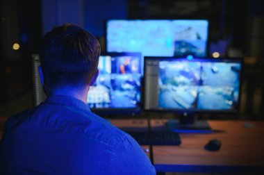 Güvenlik operatörü gece ofisindeki güvenlik kameralarını kontrol ediyor. Modern güvenlik sistemi ve sosyal güvenlik kavramı.