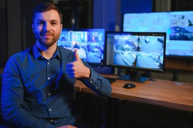 Güvenlik operatörü gece ofisindeki güvenlik kameralarını kontrol ediyor. Modern güvenlik sistemi ve sosyal güvenlik kavramı.