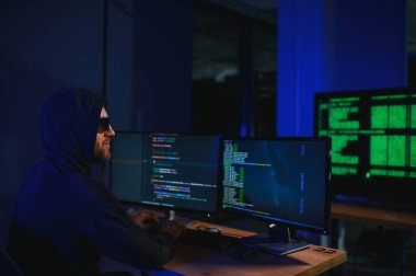 Bilgisayar ve dizüstü bilgisayar kullanarak virüs fidye virüsü kodlayan aranan hackerlar. Siber saldırı, sistem kırma ve kötü amaçlı yazılım kavramı.