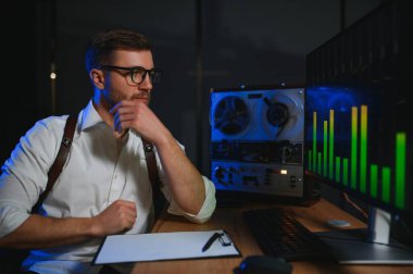 Gizli ajan kayıt cihazını dinliyormuş. Memur kulaklıkla dinleme yapıyor. Muhabbet casusluğu. İstihbarat toplama. Casusluk konsepti.