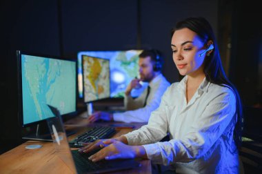 Gülümseyen arkadaş canlısı çağrı merkezi ajanı, kulaklıkla ofiste yardım hattında çalışıyor..