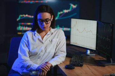 Kadın tüccar. Bayan bilgisayarla yatırım yapıyor. İş kadını hisse senedi fiyatlarını takip ediyor.