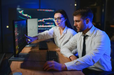 İşletme takımı yatırımı bilgisayarla çalışıyor, borsa işlemlerini planlıyor ve analiz ediyor..