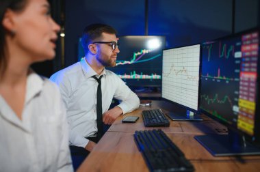 İşletme takımı yatırımı bilgisayarla çalışıyor, borsa işlemlerini planlıyor ve analiz ediyor..