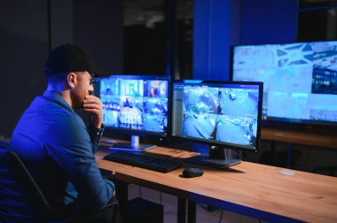 Erkek güvenlik görevlisi gözetim odasında.