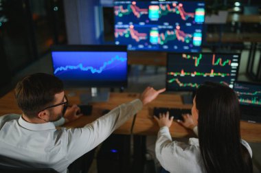 İşletme takımı yatırımı bilgisayarla çalışıyor, borsa işlemlerini planlıyor ve analiz ediyor..