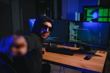 Bilgisayar ve dizüstü bilgisayar kullanarak virüs fidye virüsü kodlayan aranan hackerlar. Siber saldırı, sistem kırma ve kötü amaçlı yazılım kavramı.