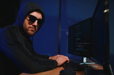 Bilgisayar ve dizüstü bilgisayar kullanarak virüs fidye virüsü kodlayan aranan hackerlar. Siber saldırı, sistem kırma ve kötü amaçlı yazılım kavramı.