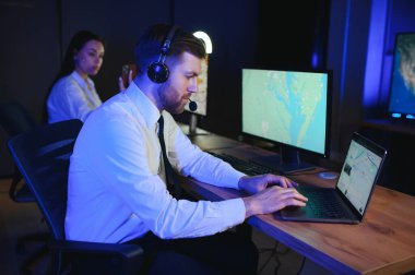 Tamirat merkezi. Seyrüsefer kontrol panosunda otururken kulaklıkla çalışan neşeli kadın ve erkek portresi.