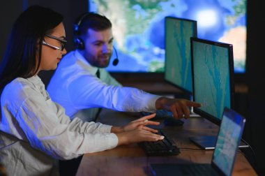 Gülümseyen arkadaş canlısı çağrı merkezi ajanı, kulaklıkla ofiste yardım hattında çalışıyor..